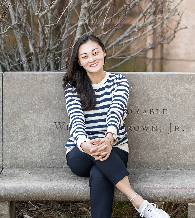 Eye Doctor Palo Alto CA Cindy Pouw Sitting On Concrete Bench HP Eye Doctor Cindy Pouw Sitting On Concrete Bench In Striped Shirt Smiling